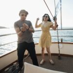 A joyful couple dancing on a yacht deck under the summer sun, capturing the essence of a carefree vacation.